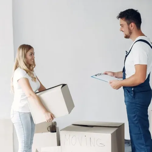 Woman moving and using a boxes Woman moving. Lady use a boxes. Girl in a white t-shirt.